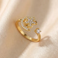 A diagonal perspective of a gold Calm spinning sun and star ring resting on textured satin.