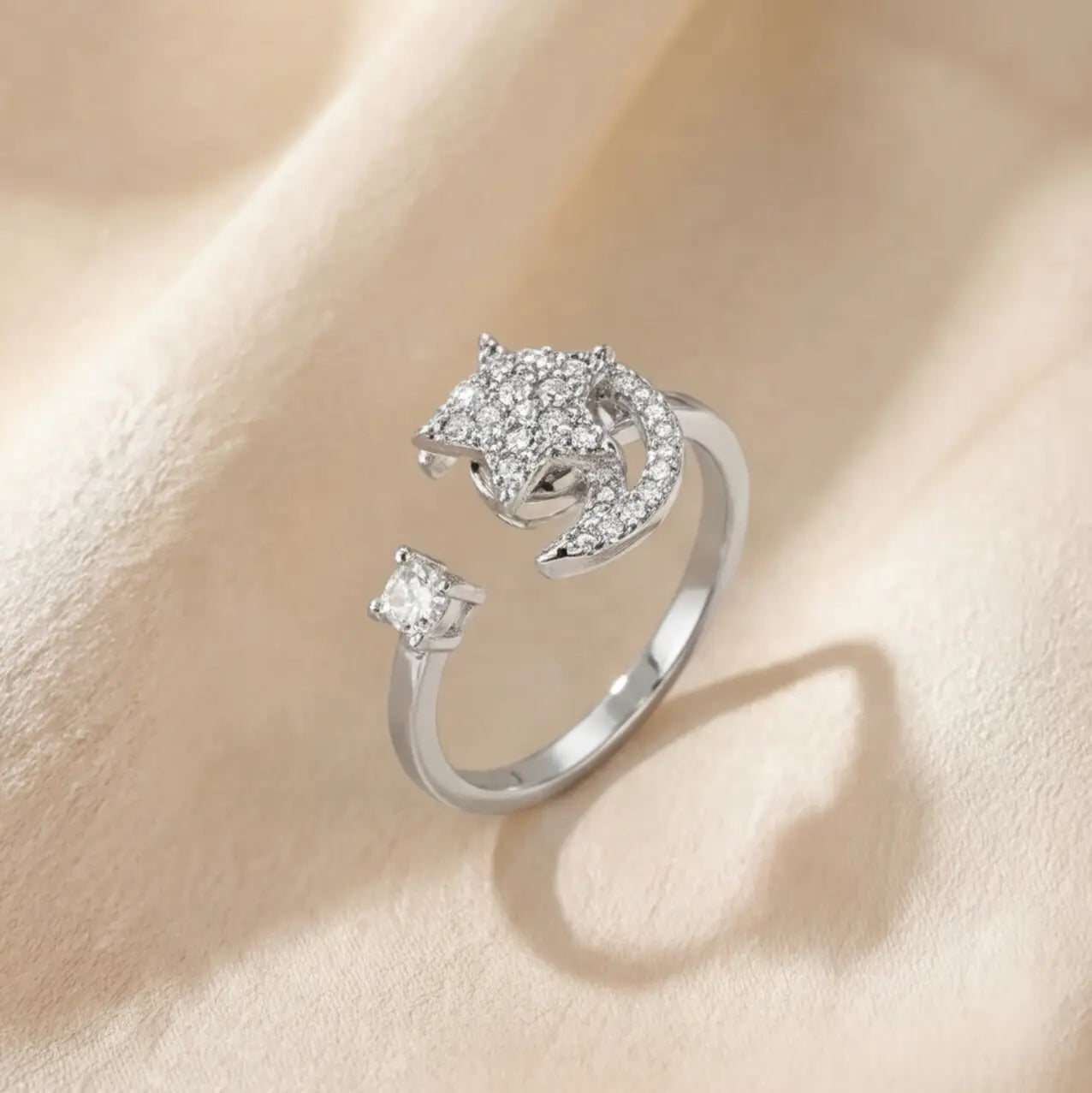 Angled view of the silver Pausa spinning sun star fidget calm ring featuring a crystal-encrusted sun and solitaire stone.