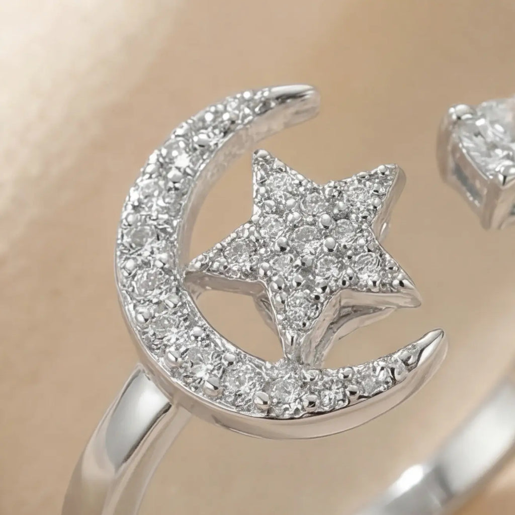 Extreme close-up of the silver Pausa spinning sun star fidget calm ring showing the shimmering star and sun charms.