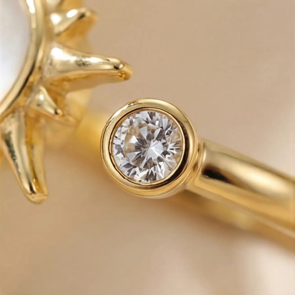 Close up of gold sunburst calm ring with bezel set clear accent stone