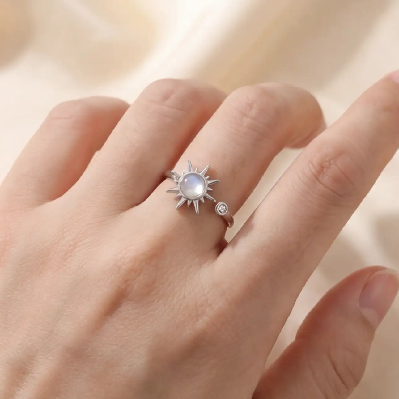 Silver celestial sunburst calm ring worn on hand close up
