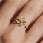 Close up of Lunela Attimo gold pavé pinwheel calm spinner ring worn on finger