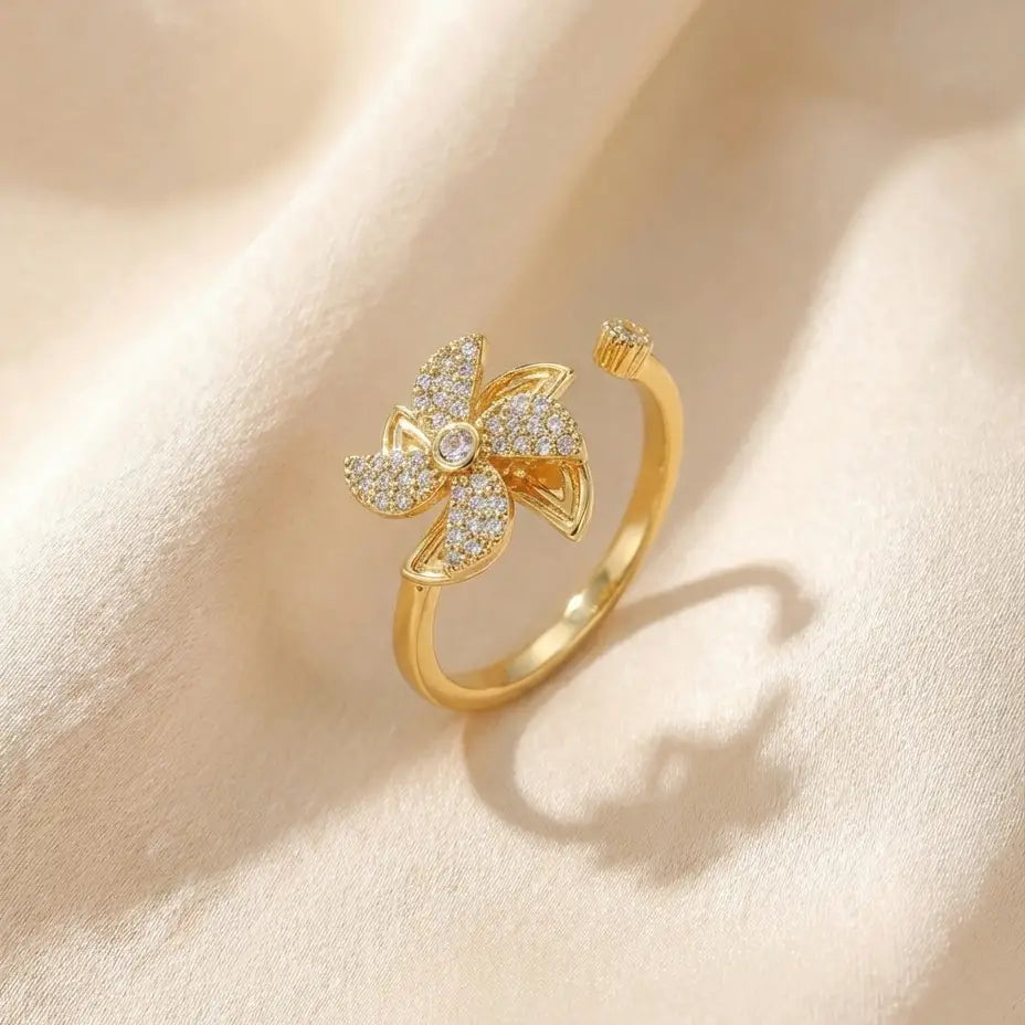 Lunela Attimo gold pavé pinwheel calm spinner ring standing upright on satin background