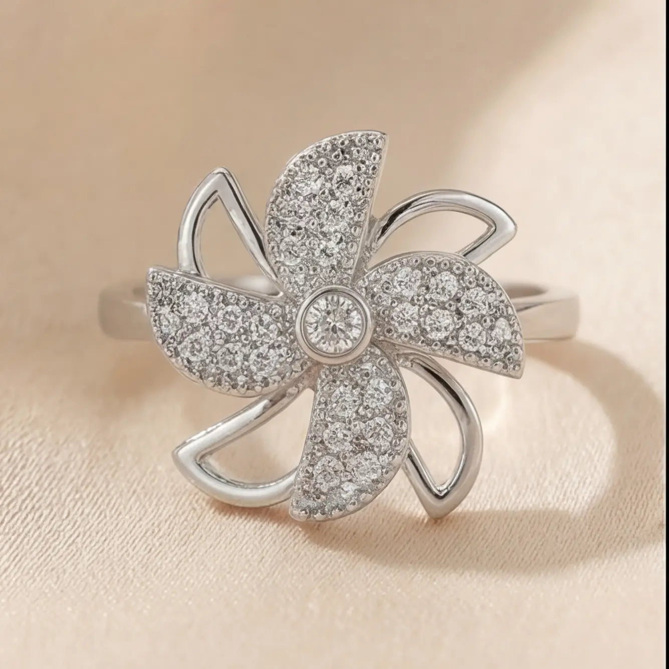 Front centered view of Lunela Attimo silver pavé pinwheel calm spinner ring with five petal design