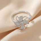 Full view of Lunela Attimo silver pavé pinwheel calm spinner ring on champagne satin fabric