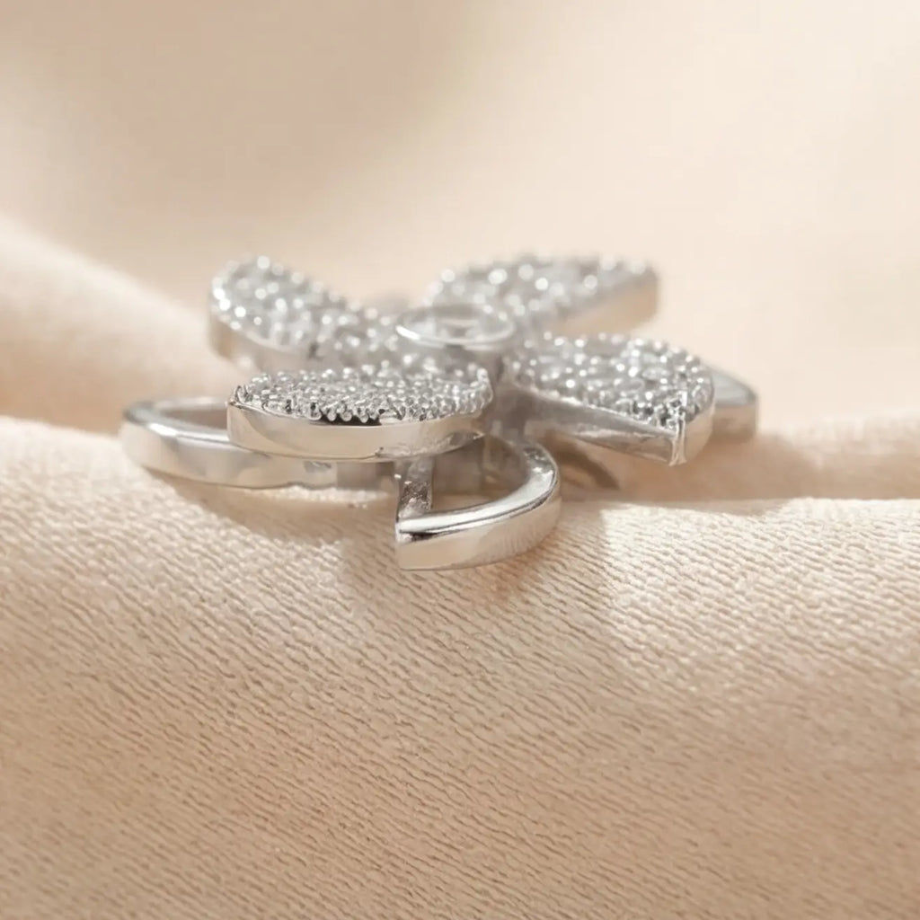 Side angle view of Lunela Attimo silver pavé pinwheel calm spinner ring showing open petal frame