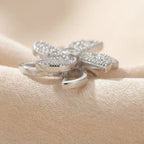 Side angle view of Lunela Attimo silver pavé pinwheel calm spinner ring showing open petal frame