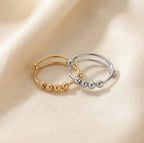 Gold and silver Centro spinner rings displayed side by side to compare finishes and color.