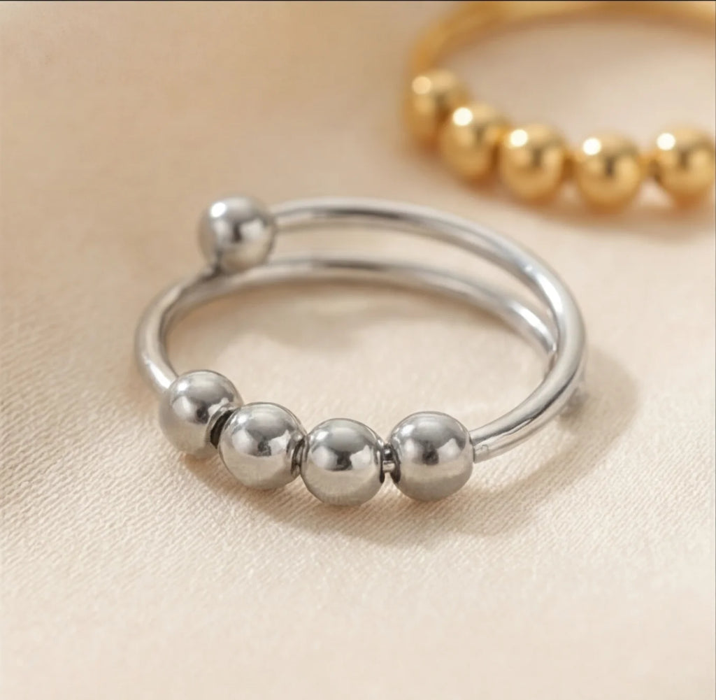 Angled view of the silver LUNÉLA Centro spinner ring showing its double band and rotating bead detail.
