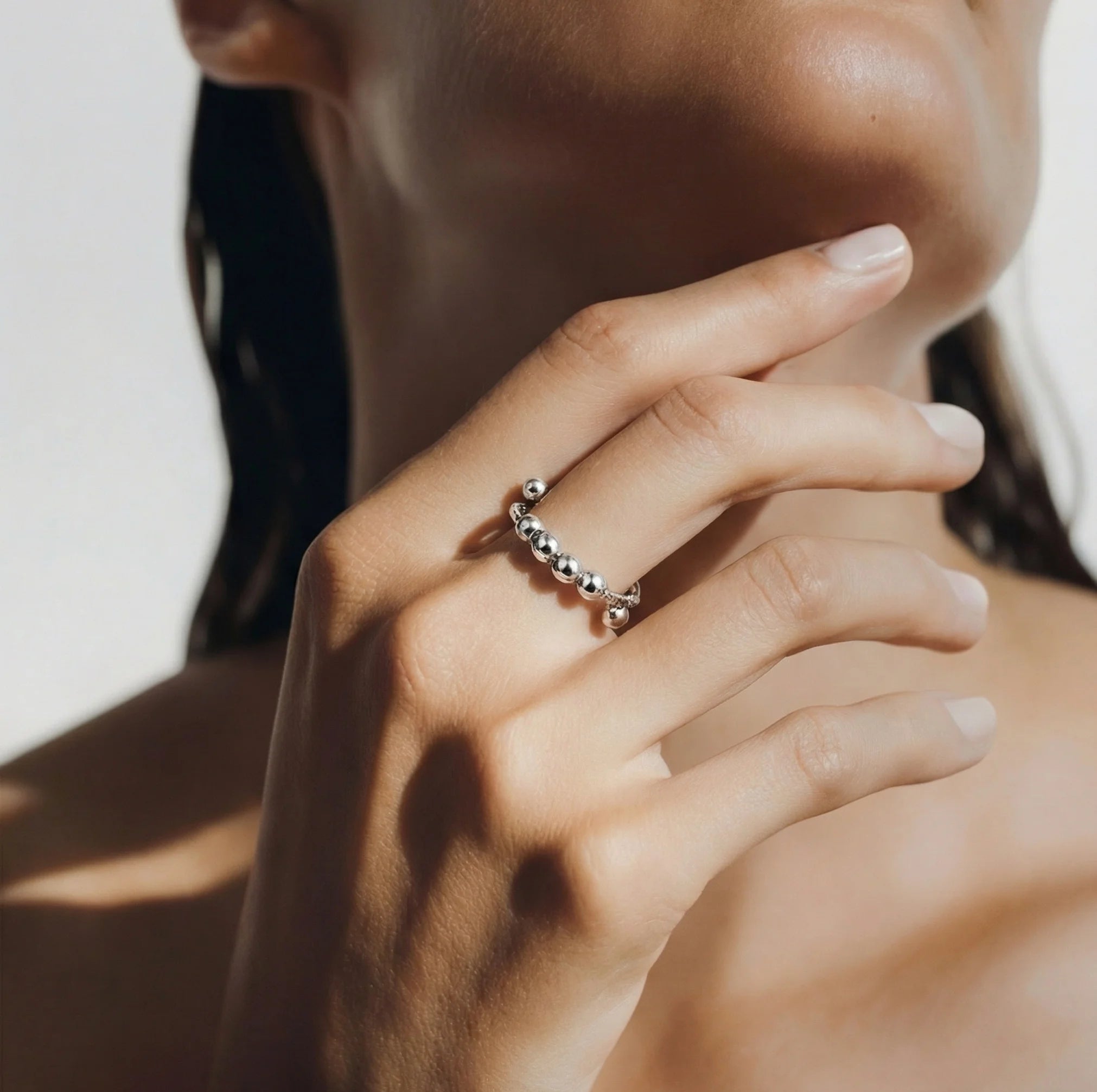 Silver LUNÉLA Centro spinner ring worn on a woman’s hand offering elegant anxiety relief.