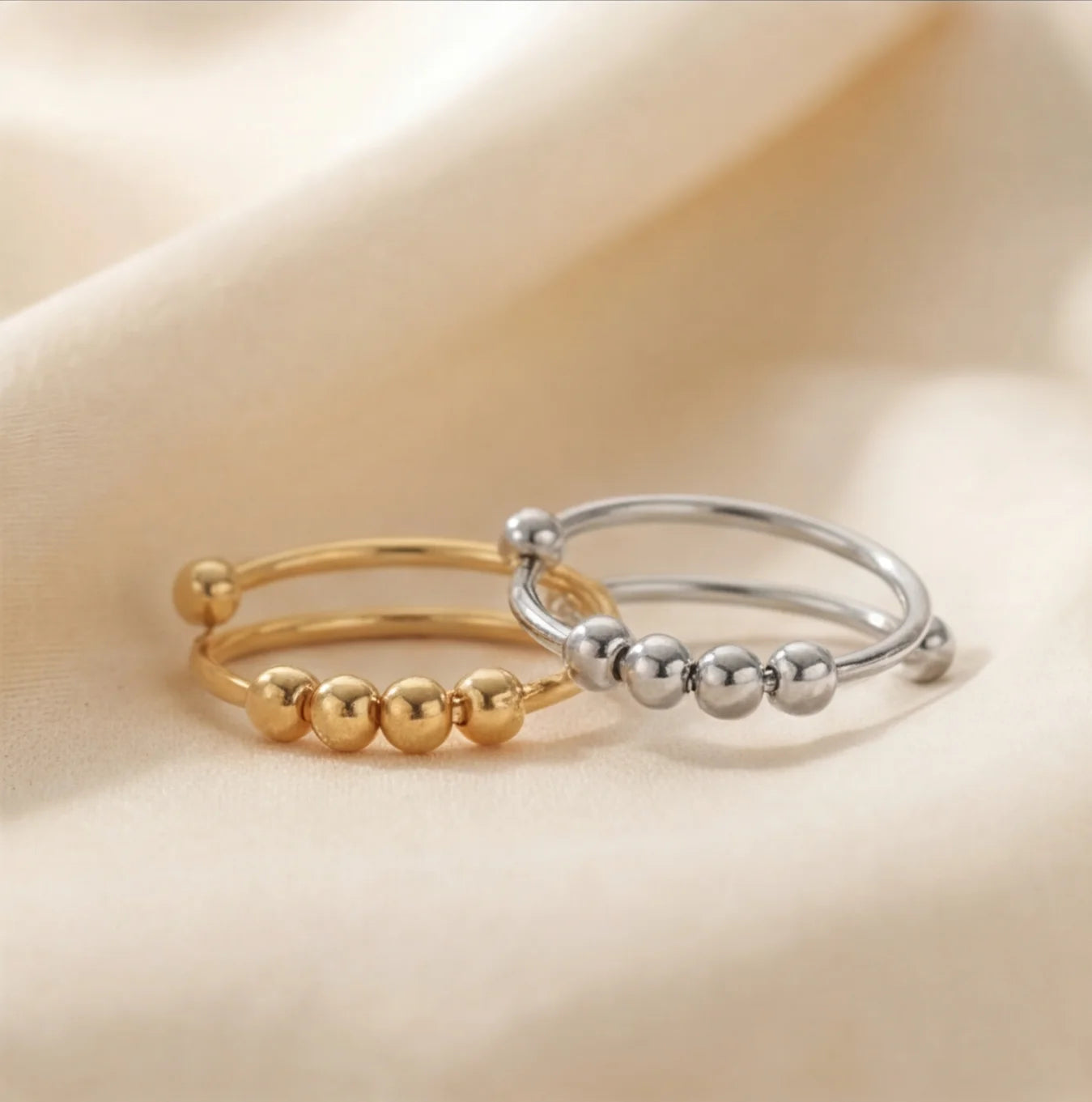 Gold and silver LUNÉLA Centro spinner rings styled together to show both color options for anxiety relief.