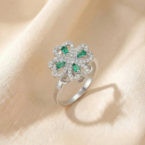 Angled view of gold clover flower calm ring with purple stones