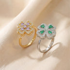 Gold purple clover calm ring and silver green clover ring side by side on silk