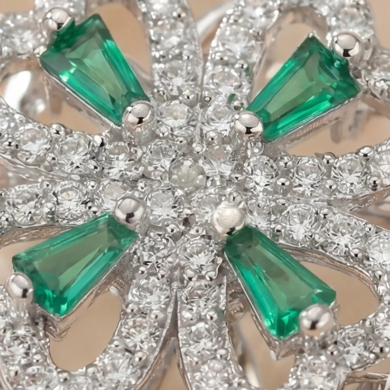 Macro detail of silver clover flower calm ring with green gemstones and pavé crystals