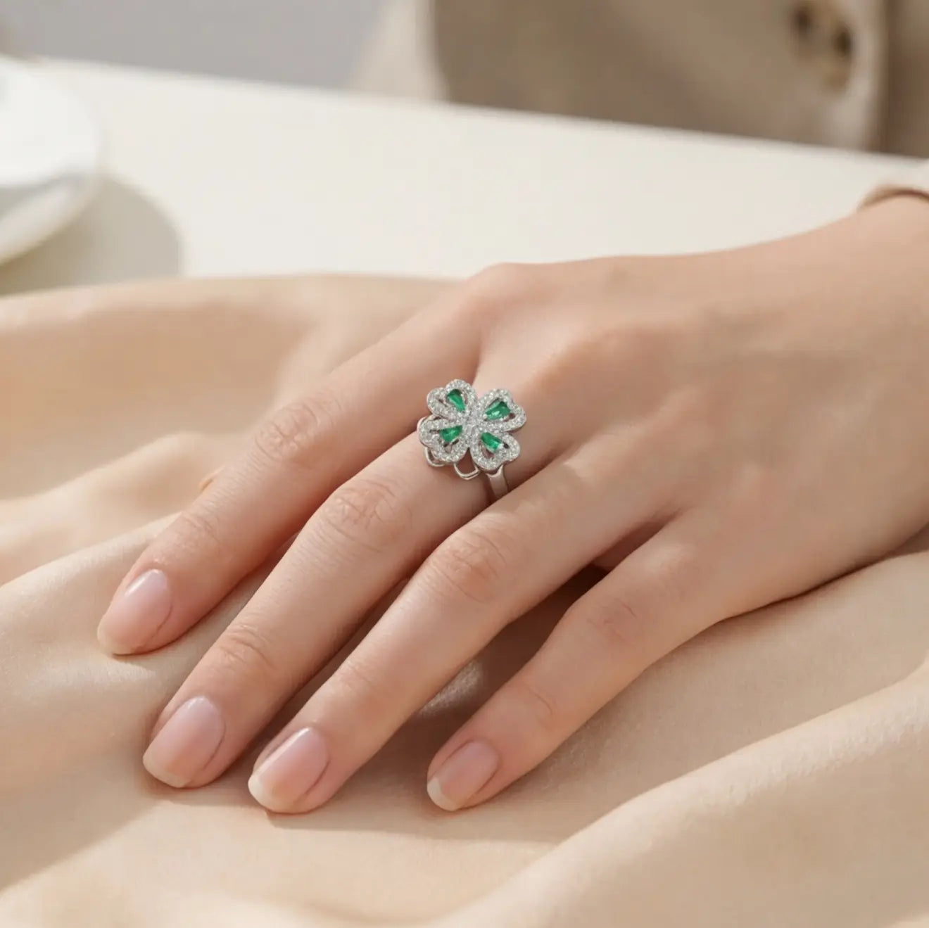 Woman wearing silver clover flower calm ring with green gemstones on hand
