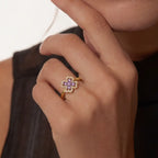 Woman wearing gold clover flower calm ring with purple stones