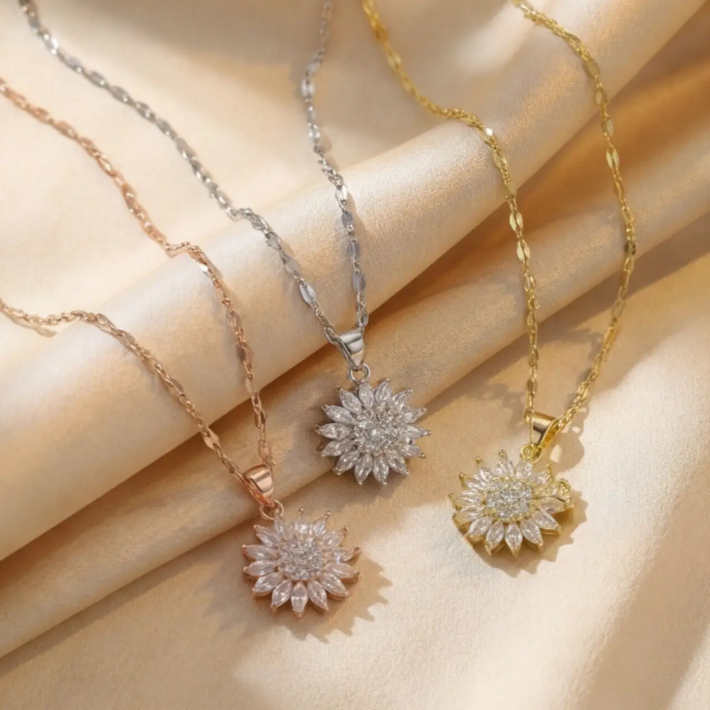 Lunela Collana flower pendant necklace shown in gold, silver and rose gold finishes on champagne satin