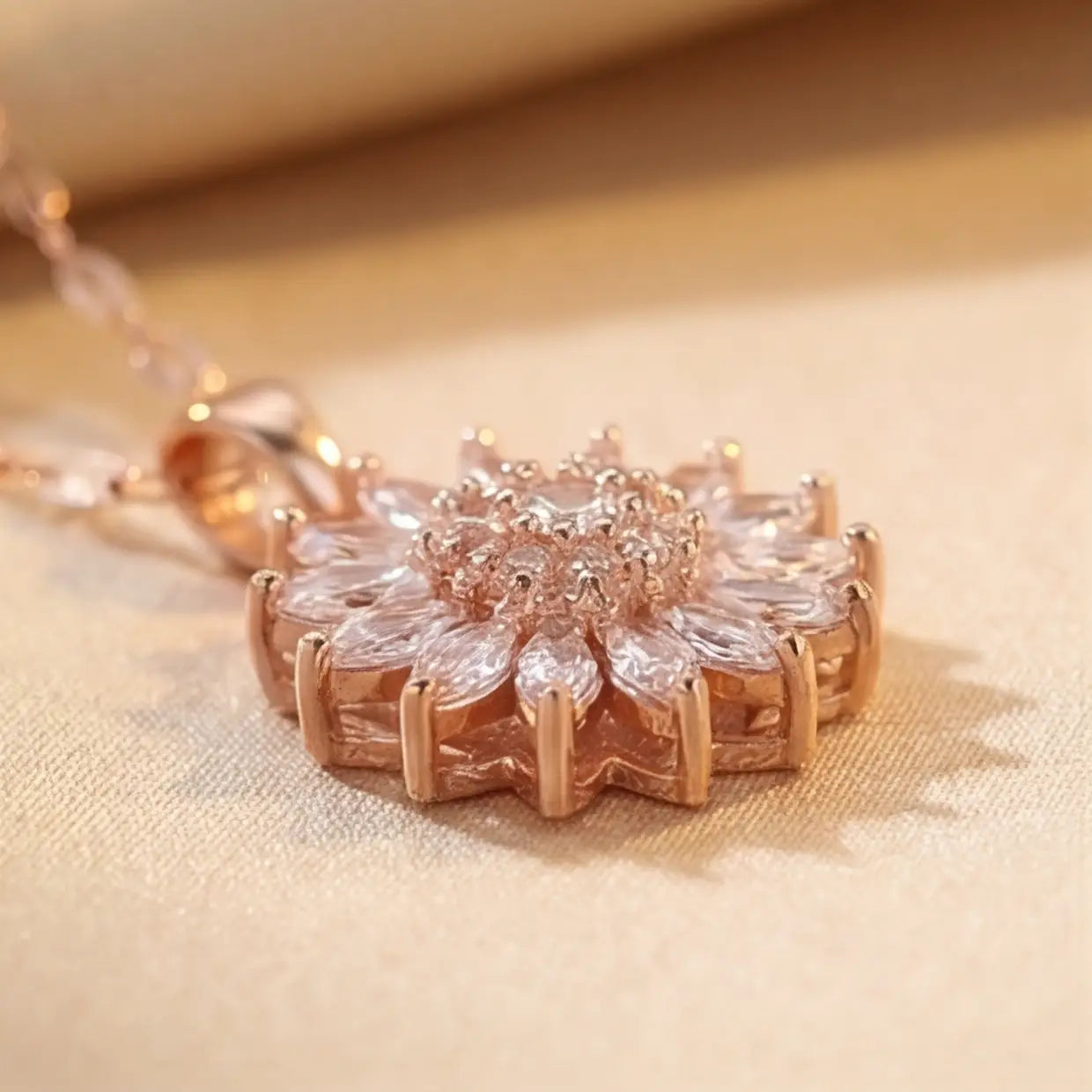 Lunela Collana rose gold flower pendant necklace side profile showing prong setting and layered marquise cut crystals on champagne satin background
