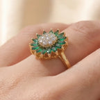 Gold sunflower calm ring with green marquise stones and crystal center worn on hand