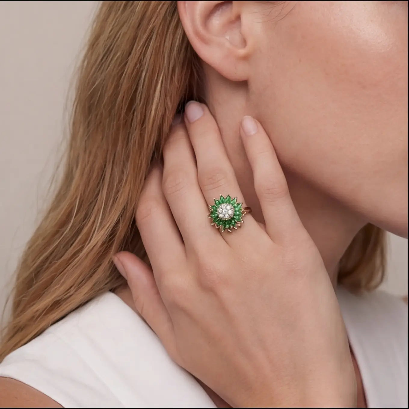 Woman wearing gold sunflower calm ring with green marquise stones and crystal center close portrait view