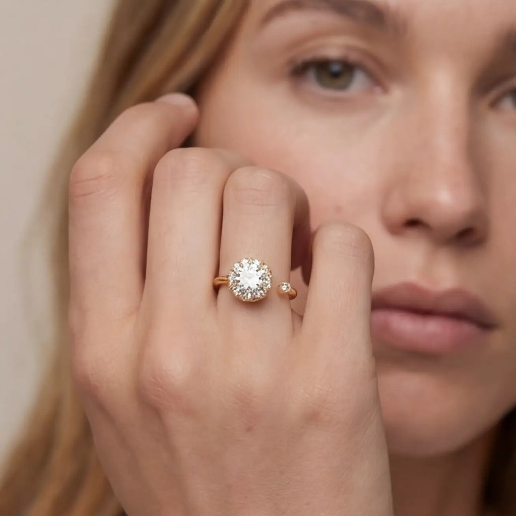 Gold flower cluster open calm ring with clear stones worn on hand portrait view