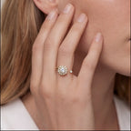 Gold flower cluster open calm ring with clear stones worn on hand near face