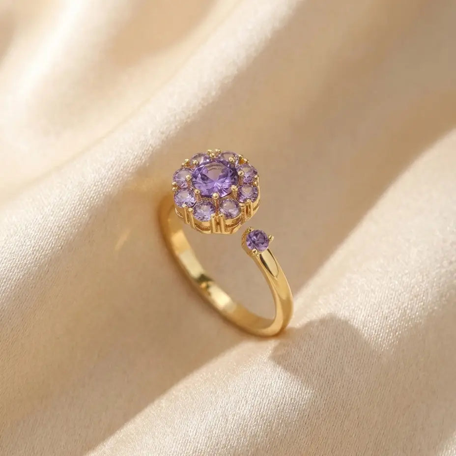 Gold flower cluster open calm ring with purple stones on silk background