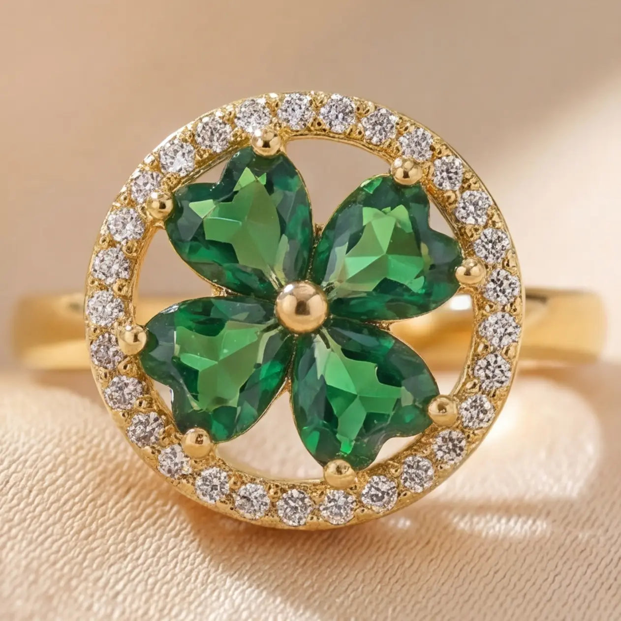 Lunela Metà gold calm spinner ring with green heart shaped stones and diamond halo