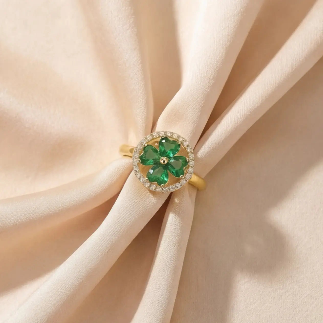 Lunela Metà gold calm spinner ring styled on folded champagne satin background