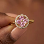 Macro front view of Lunela Metà gold calm spinner ring with pink heart shaped stones and diamond halo