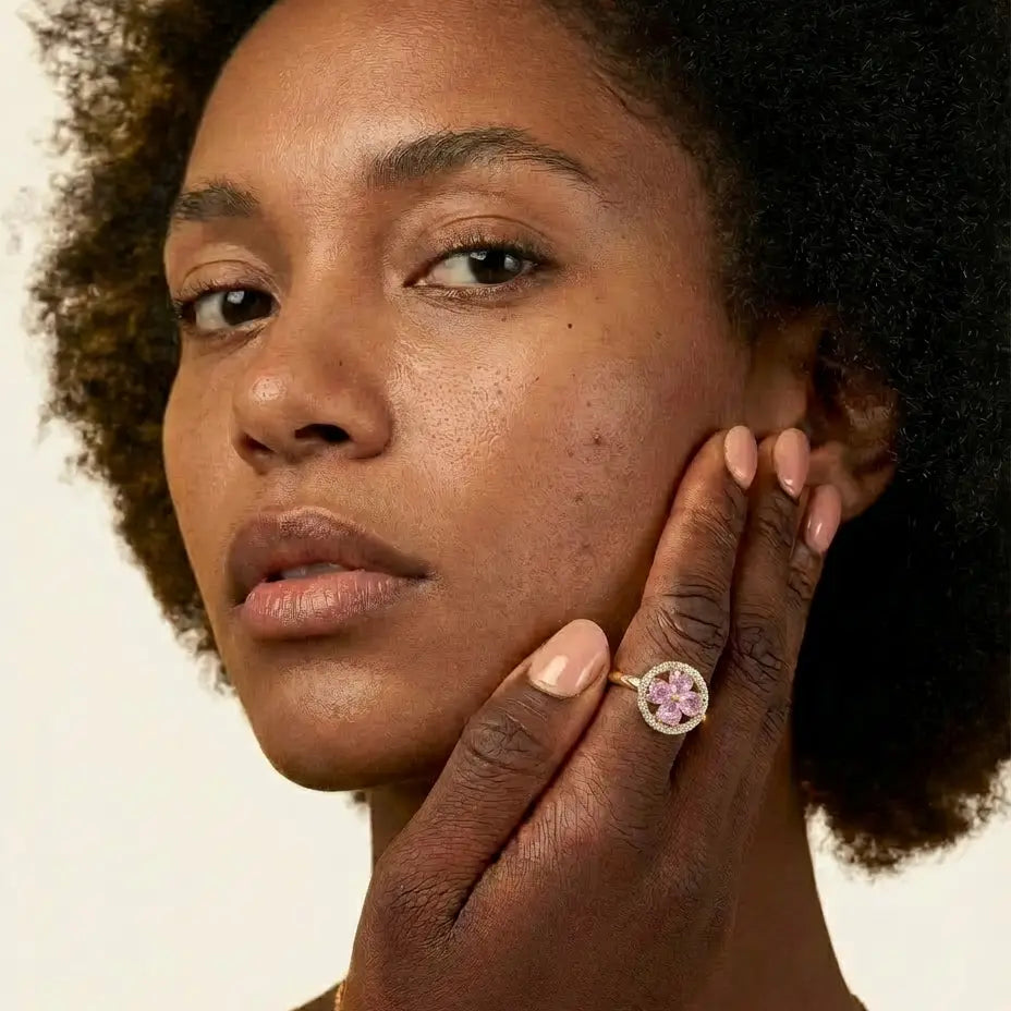 Model wearing Lunela Metà gold calm spinner ring with pink heart cut stones and pavé halo