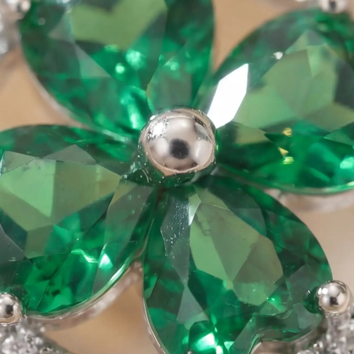 Macro detail of Lunela Metà green calm spinner ring showing heart cut stones and polished center bead