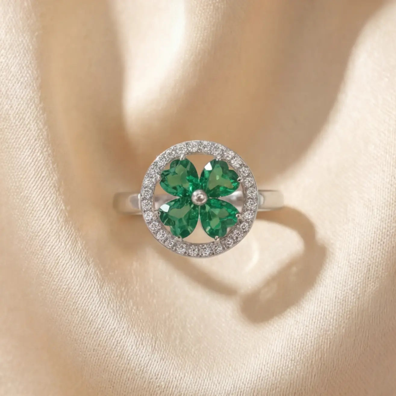 Front view of Lunela Metà silver calm spinner ring with green clover stones and pavé halo