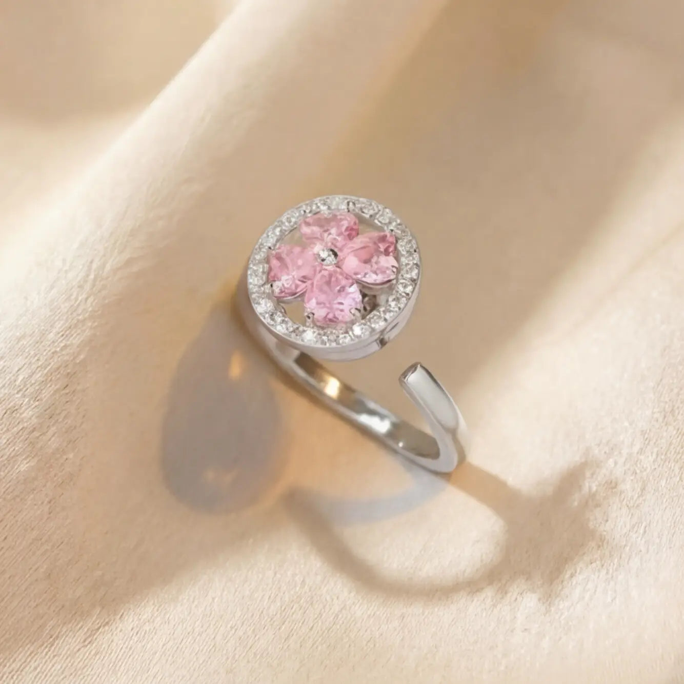 Lunela Metà silver calm spinner ring with pink clover stones and pavé halo