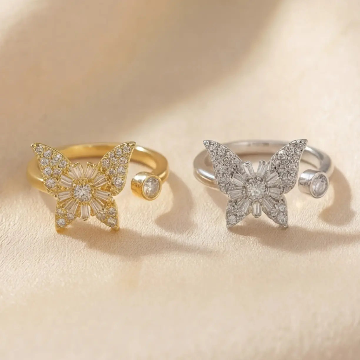 Raggio butterfly calm ring collection in gold and silver adjustable open band with crystal stones on cream background