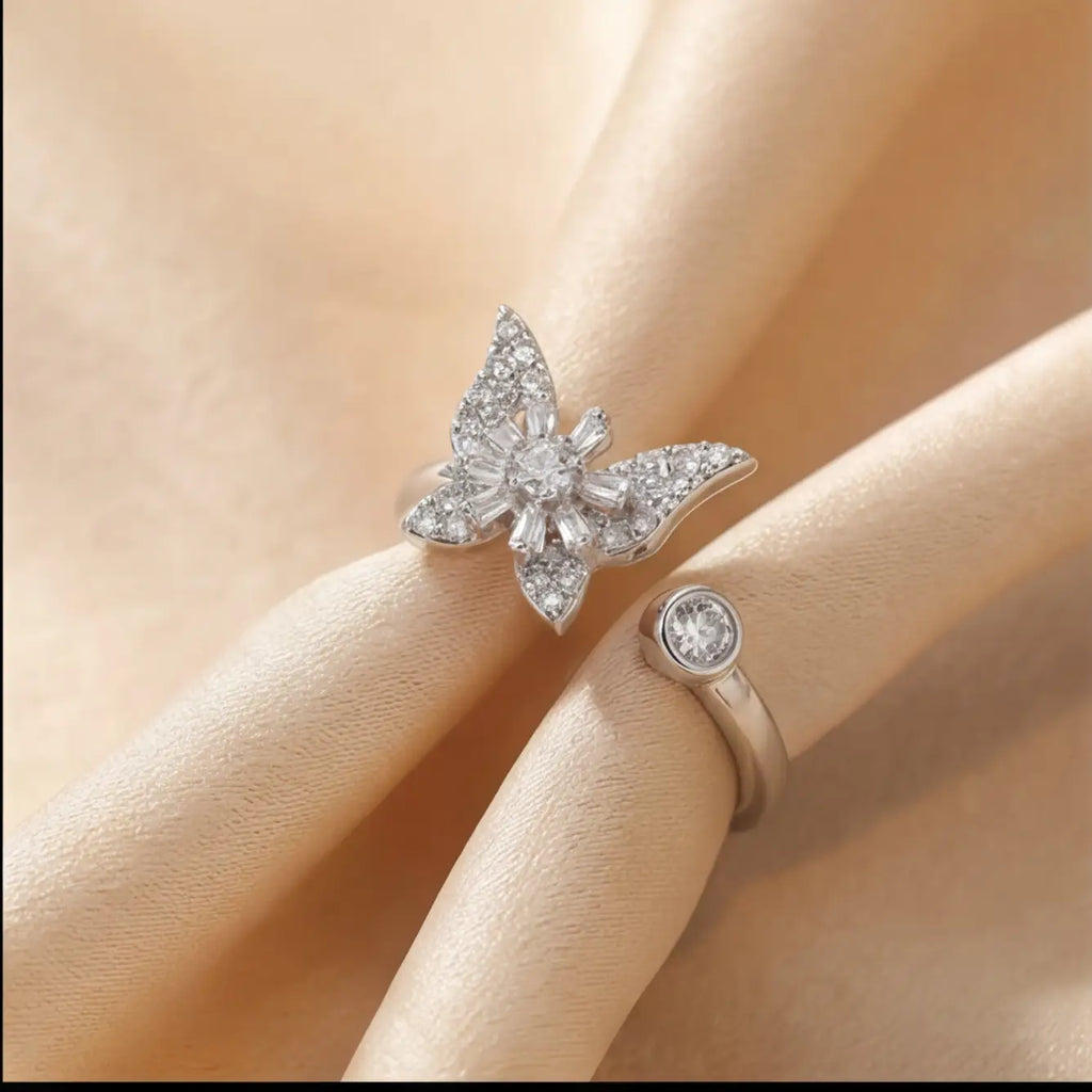 Raggio silver butterfly calm ring adjustable open band with pavé crystal stones on cream fabric background