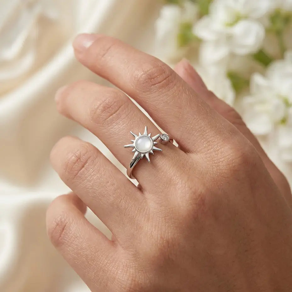 Silver Raggio sunburst calm ring with moonstone center worn on woman’s hand in natural light